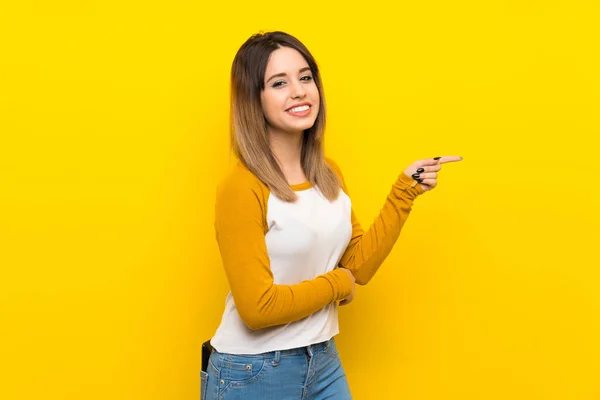 Όμορφη Νεαρή Γυναίκα Πάνω Από Απομονωμένο Κίτρινο Τοίχο Δείχνοντας Δάχτυλο — Φωτογραφία Αρχείου