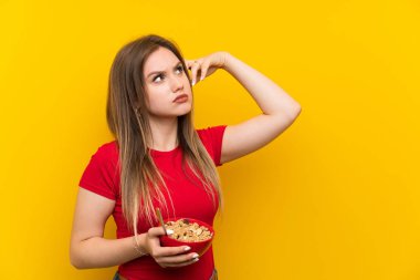 Genç genç kız şüpheleri olan tahıl bir kase tutan ve yüz ifadesi karıştırmayın