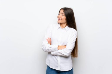 İzole edilmiş beyaz arka planı olan genç bir kadın yan tarafa bakıyor.