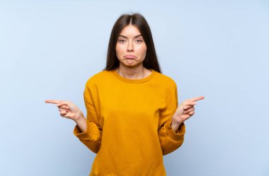 Izole mavi duvar üzerinde Kafkas genç kadın lateraller şüpheleri olan işaret