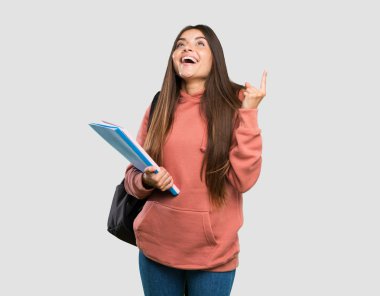 Genç öğrenci kadın dizüstü bilgisayarlar kadar işaret tutan ve izole gri arka plan üzerinde şaşırttı