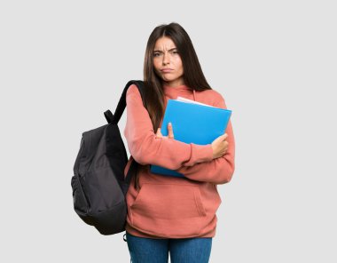 Defter tutan genç öğrenci kadın izole gri arka plan üzerinde üzgün hissediyorum