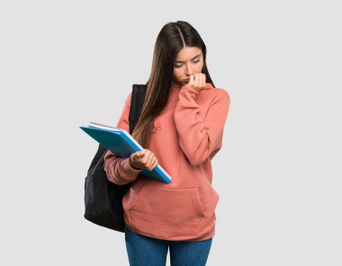 İzole gri arka plan üzerinde şüpheleri olan deftertutan genç öğrenci kadın