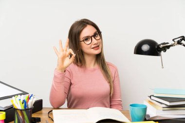 Genç öğrenci kız parmakları ile ok işareti gösteren odasında