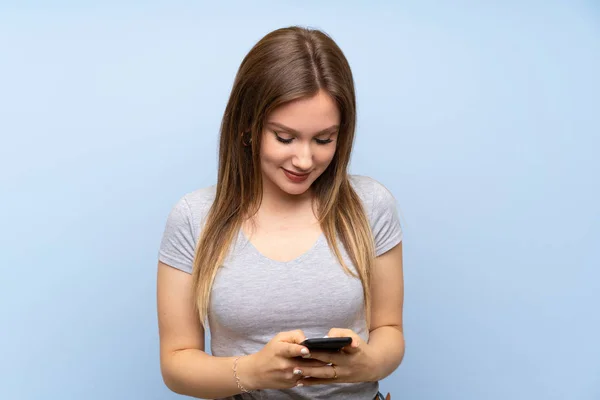 Teenager Girl Isolated Blue Wall Sending Message Mobile — Stock Photo, Image