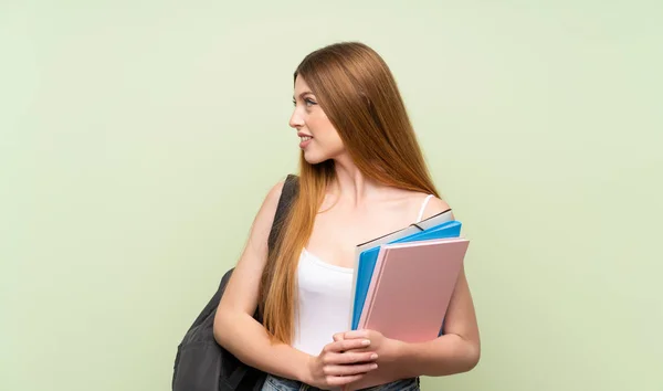 Joven Estudiante Sobre Fondo Verde Aislado Mirando Hacia Lado —  Fotos de Stock