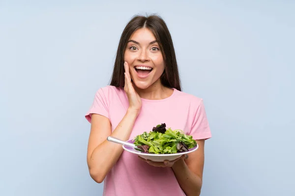 Jonge Vrouw Met Salade Geïsoleerde Blauwe Achtergrond Met Verrassing Geschokt — Stockfoto