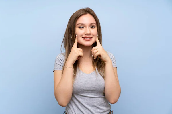 Adolescente Chica Sobre Aislada Pared Azul Sonriendo Con Una Expresión —  Fotos de Stock