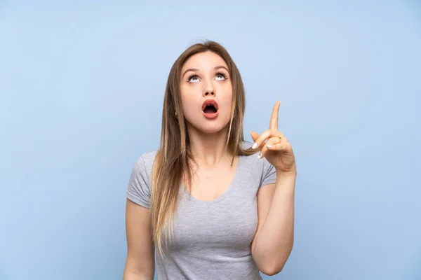 Adolescente Chica Sobre Aislado Azul Pared Apuntando Hacia Arriba Sorprendido —  Fotos de Stock