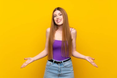 Izole sarı arka plan üzerinde genç kadın gülümseyerek