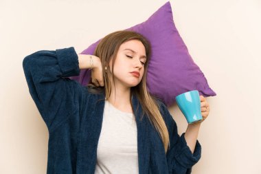 Bir fincan kahve tutan pijama genç kız