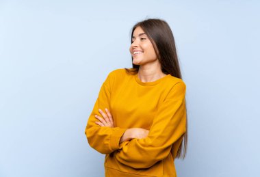 Izole mavi duvar üzerinde yan bakan Kafkas genç kadın