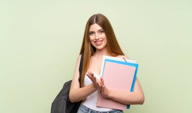 Izole yeşil arka plan üzerinde genç öğrenci kadın alkışlıyor