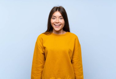 Sürpriz yüz ifadesi ile izole mavi duvar üzerinde Kafkas genç kadın