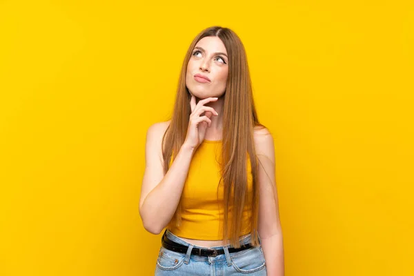 Mujer Joven Sobre Fondo Amarillo Aislado Pensando Una Idea — Foto de Stock