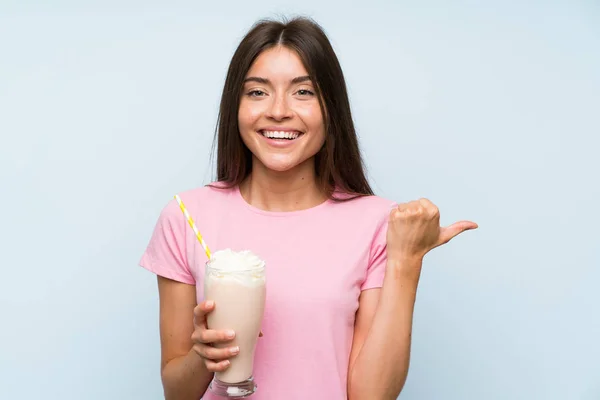 Jovem Com Batido Morango Sobre Fundo Azul Isolado Apontando Para — Fotografia de Stock