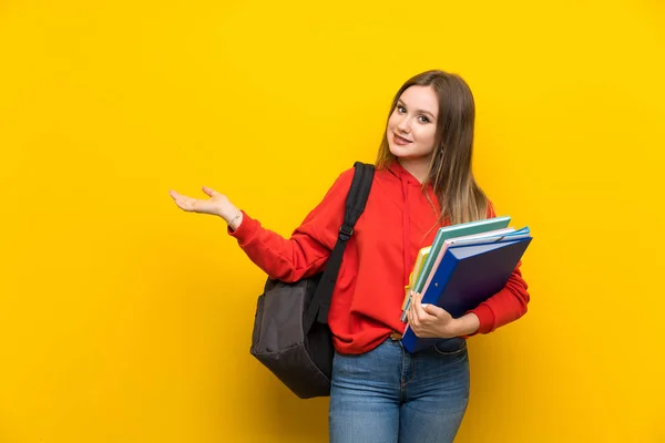 Adolescente Estudiante Sobre Fondo Amarillo Extendiendo Las Manos Lado Para — Foto de Stock