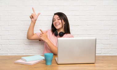 İşaret parmağı ile işaret eden bir dizüstü bilgisayar ile genç Meksikalı kadın harika bir fikir