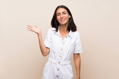 Arka planda izole edilmiş genç bir kadın, bir ilan vermek için avucunun içinde hayali bir alan tutuyor.