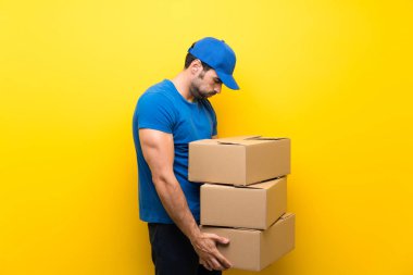 Izole sarı duvar üzerinde genç teslimat adam