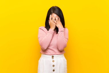 Yorgun ve hasta ifade ile izole sarı arka plan üzerinde Genç Meksikalı kadın