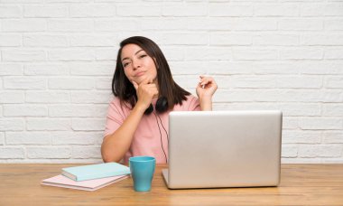 Bir dizüstü bilgisayar ile genç Meksikalı kadın bir fikir düşünme