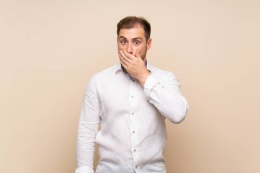 Elleriyle ağız kapsayan izole arka plan üzerinde Blonde adam