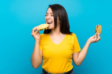 Izole mavi arka plan üzerinde genç Meksikalı kadın