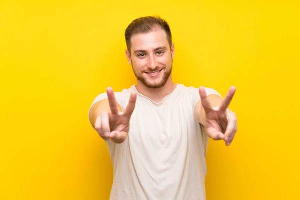 Hombre Guapo Sobre Fondo Amarillo Sonriendo Mostrando Signo Victoria — Foto de Stock