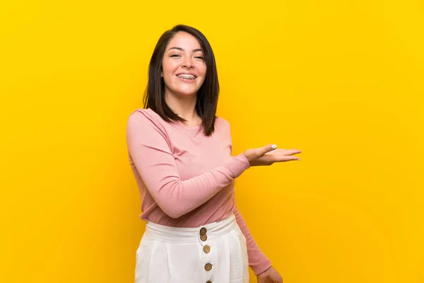 Jonge Mexicaanse Vrouw Geïsoleerde Gele Achtergrond Presenteert Een Idee Terwijl — Stockfoto