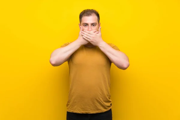 Homem Loiro Sobre Isolado Amarelo Parede Cobrindo Boca Com Mãos — Fotografia de Stock