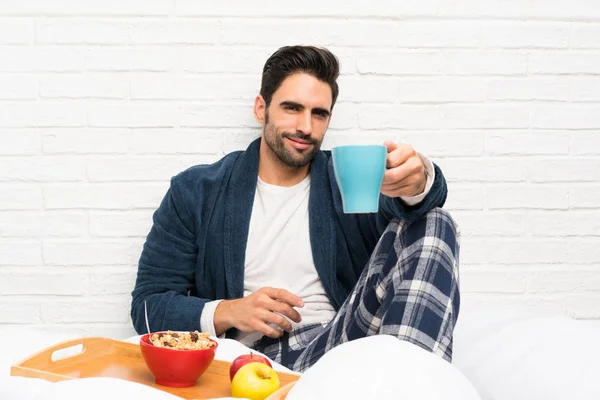 Hombre en la cama con bata y desayunando —  Fotos de Stock