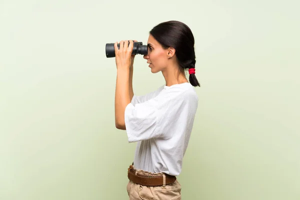 Jonge Vrouw Geïsoleerde Groene Achtergrond Met Zwarte Verrekijker — Stockfoto