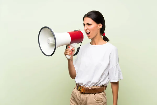 Jonge Vrouw Geïsoleerde Groene Achtergrond Schreeuwen Door Een Megafone — Stockfoto