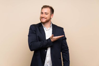 Sarışın adam izole arka plan üzerinde doğru gülümseyerek bakarken bir fikir sunan