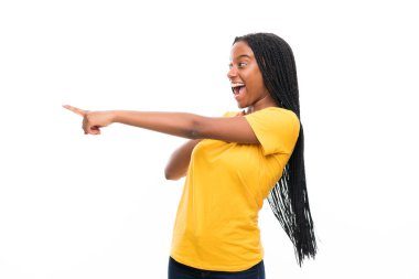 Izole beyaz arka plan yan işaret parmak üzerinde uzun örgülü saçlı Afro-Amerikan genç kız