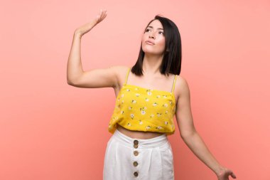 Yorgun ve hasta ifade ile izole duvar üzerinde Genç Meksikalı kadın