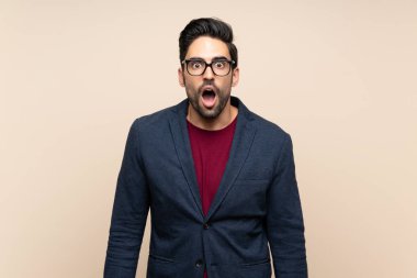 Sürpriz yüz ifade ile izole arka plan üzerinde yakışıklı genç adam