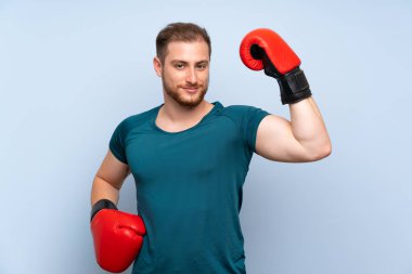 Boks eldiven ile mavi duvar üzerinde sarışın spor adam