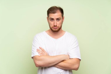 Yeşil arka plan üzgün üzerinde Yakışıklı adam