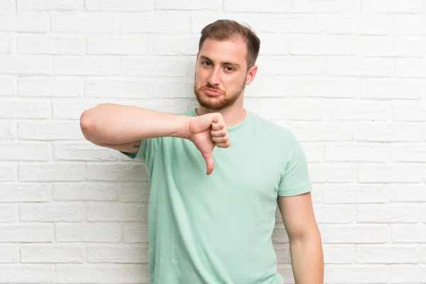 Blonde Man Brick Wall Showing Thumb Sign — Stock Photo, Image