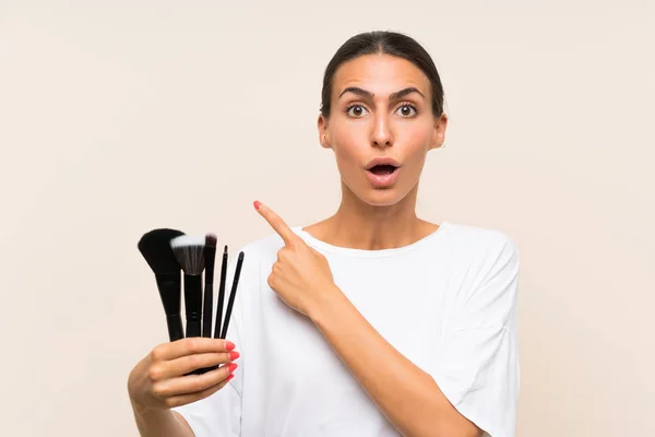 Mujer Joven Sosteniendo Una Gran Cantidad Cepillo Maquillaje Sorprendido Apuntando — Foto de Stock