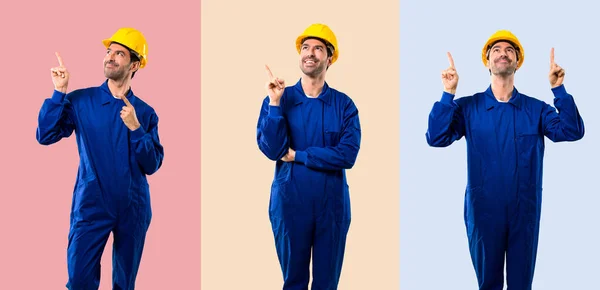 Junger Arbeiter mit Helm, der mit dem Zeigefinger zeigt — Stockfoto