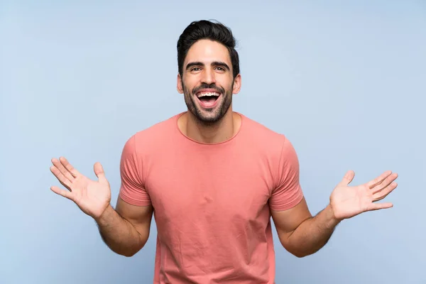 Knappe Jonge Man Roze Shirt Geïsoleerde Blauwe Achtergrond Glimlachend Veel — Stockfoto