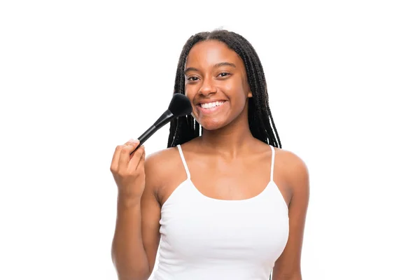 Adolescente afro-américaine avec de longs cheveux tressés avec une brosse de maquillage — Photo