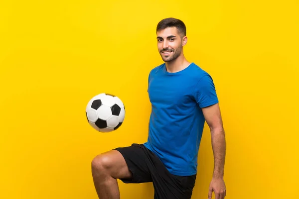 Joven jugador de fútbol guapo hombre sobre aislado pared amarilla —  Fotos de Stock