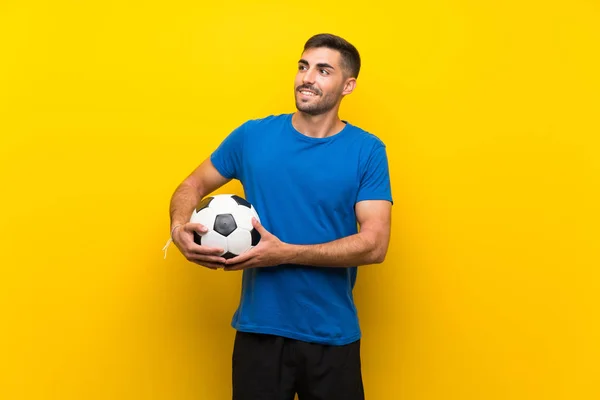 Joven Jugador Fútbol Guapo Hombre Sobre Aislado Pared Amarilla Mirando —  Fotos de Stock