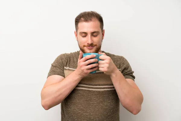 Przystojny Człowiek Białym Ścianie Trzymając Gorącą Filiżankę Kawy — Zdjęcie stockowe