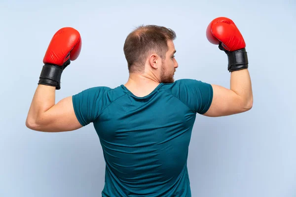 Bionda uomo sportivo sopra il muro blu con guanti da boxe — Foto Stock