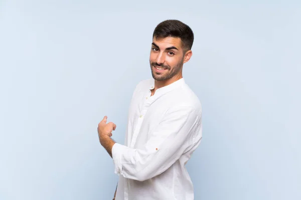 Knappe Man Met Baard Geïsoleerde Blauwe Achtergrond Wijzend Terug — Stockfoto